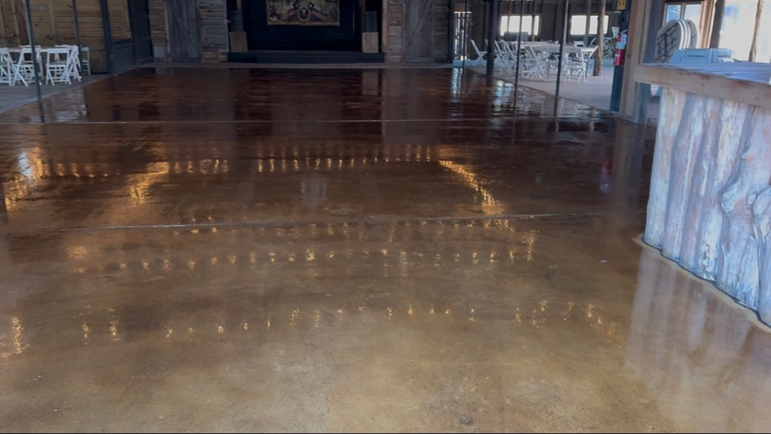 Empty polished indoor hall with a glossy brown floor and a blue stone counter on the right
