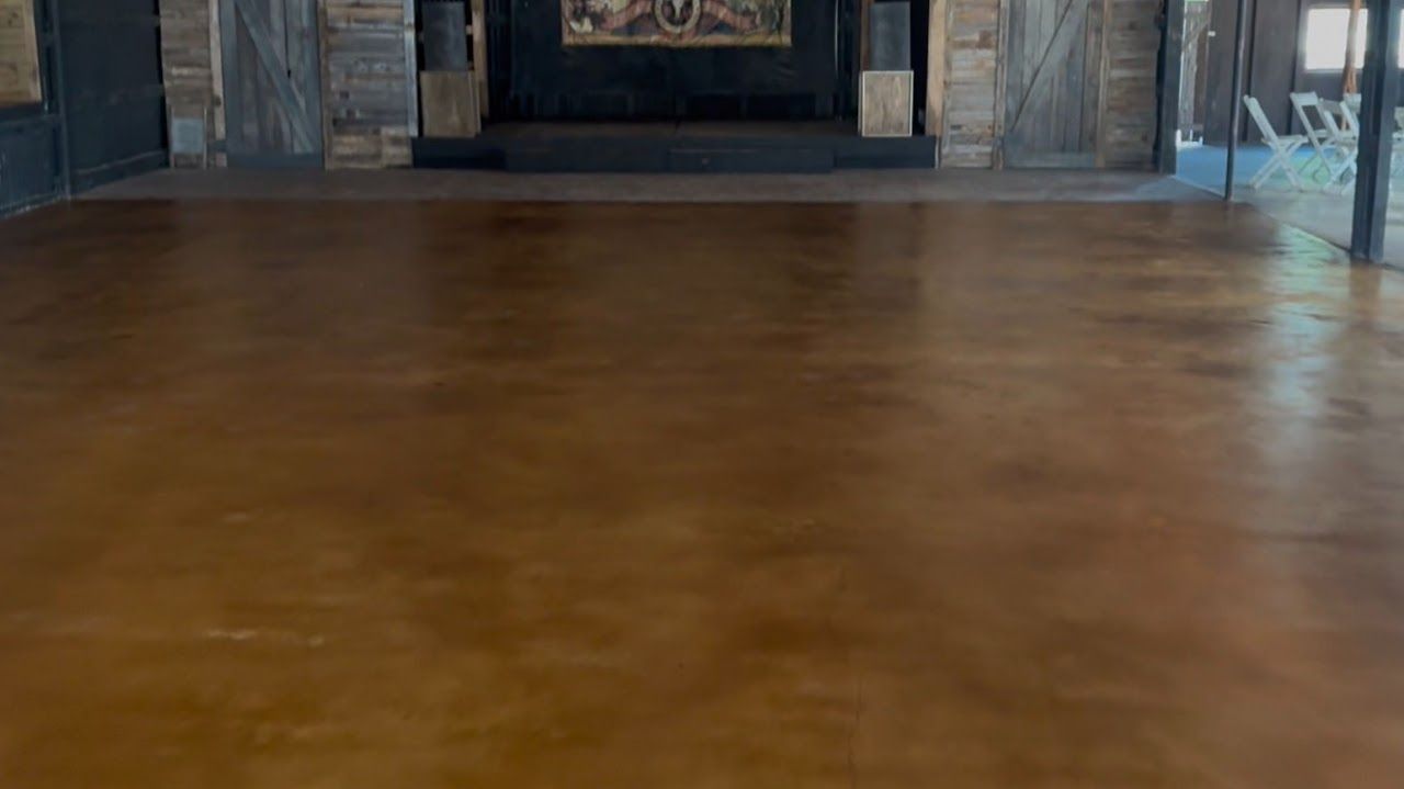 Empty wooden-floored room with a dark doorway and framed wall art in the background