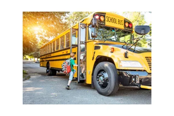 A child getting onto a yellow schoolbus.