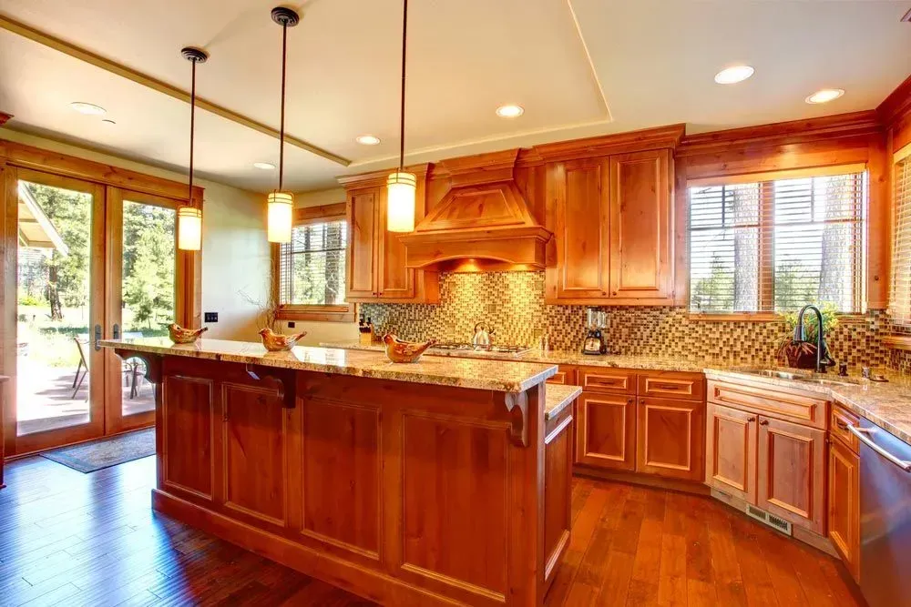 Kitchen With Wood Cabinetry and a Large Marble Island With Bar Seating — Foreshore Kitchens in Coolum Beach, QLD