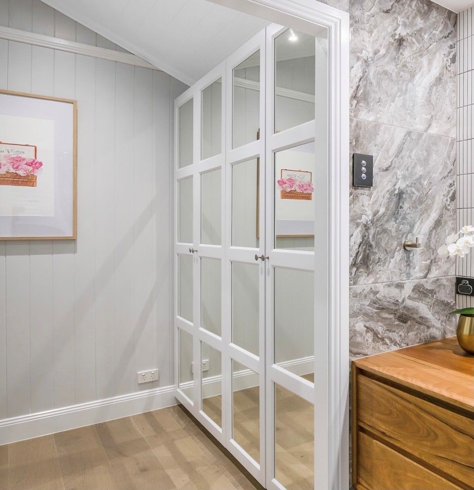 A White Glass-panelled Closet Door Next to a Grey Marble Wall — Foreshore Kitchens in Coolum, QLD