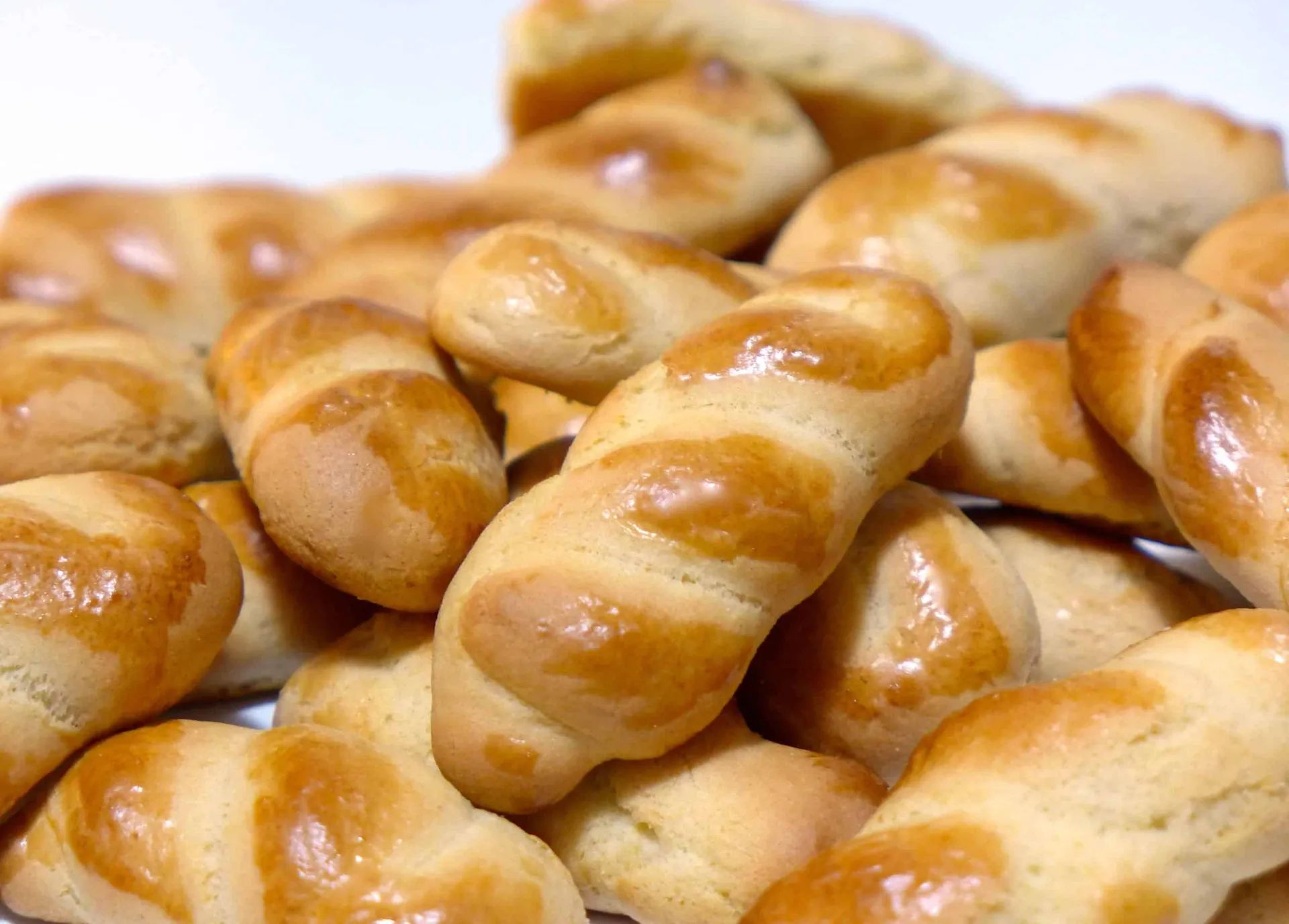 A pile of bread rolls on a white surface.