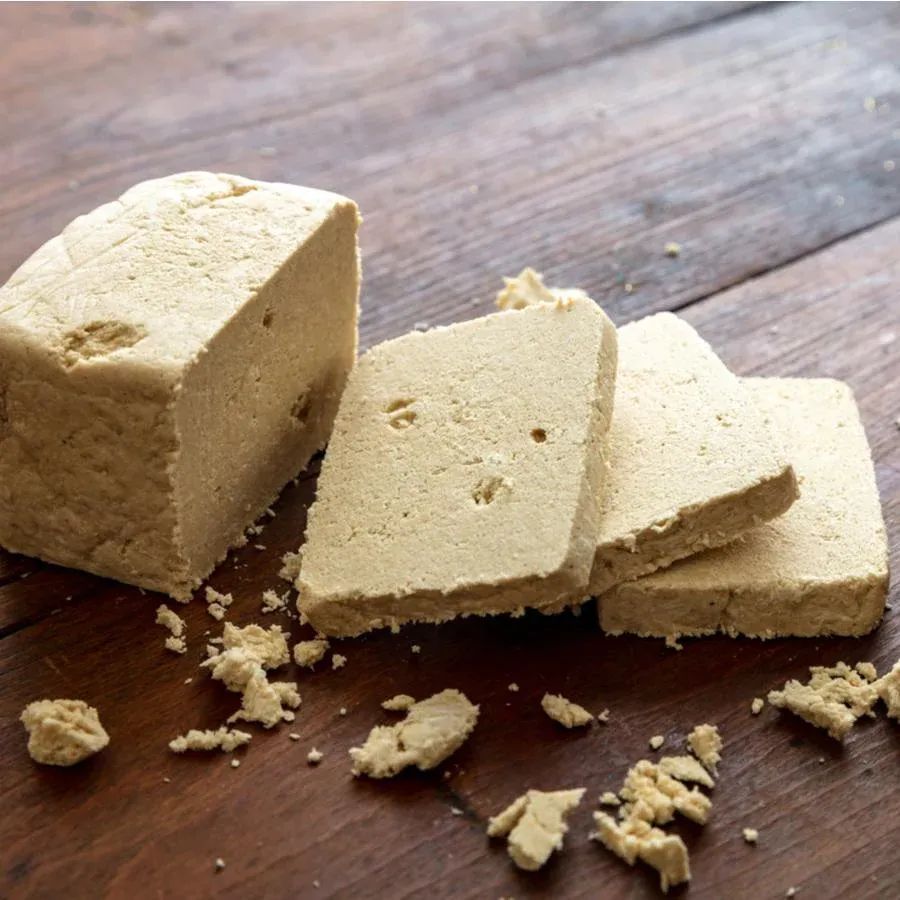 A piece of tofu is sitting on a wooden table