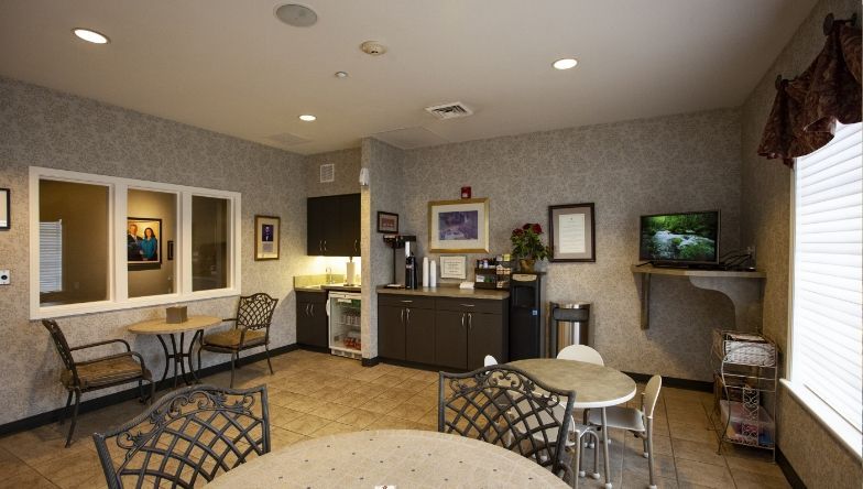 A room with tables and chairs and a television