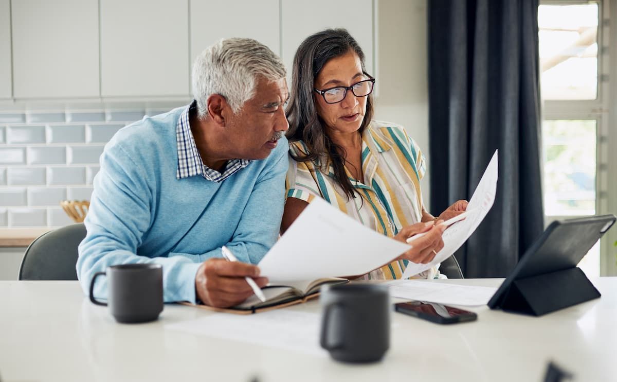 A man and a woman are sitting at a table looking at papers.