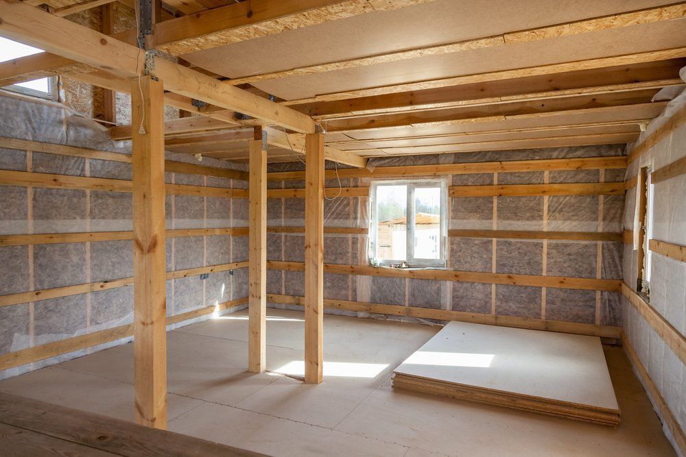 Intérieur d'une structure à ossature bois en construction, murs isolés. Lumière du soleil par la fenêtre.