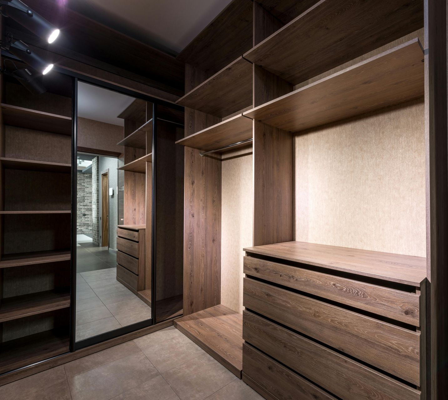 Walk-in closet with dark wood shelving, drawers, and mirrored door — Envy Glass in Nambucca Heads, NSW