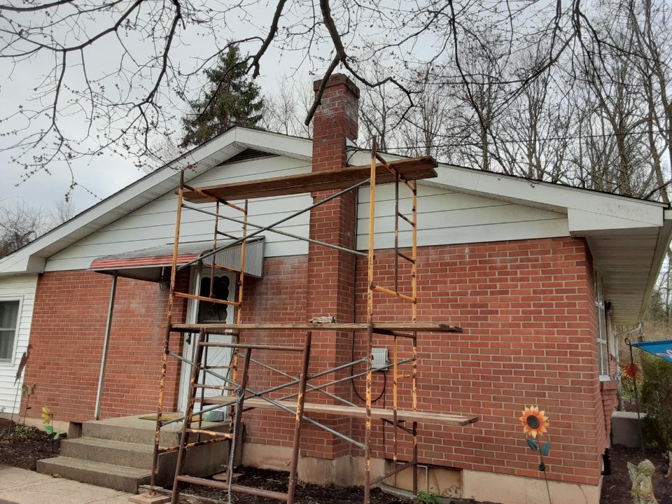 Brick house with scaffolding on the front exterior during renovation