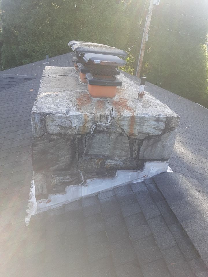 Stack of folded towels on a weathered rooftop chimney in sunlight