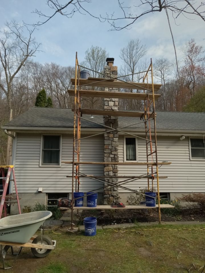 House with scaffolding around chimney during exterior repair