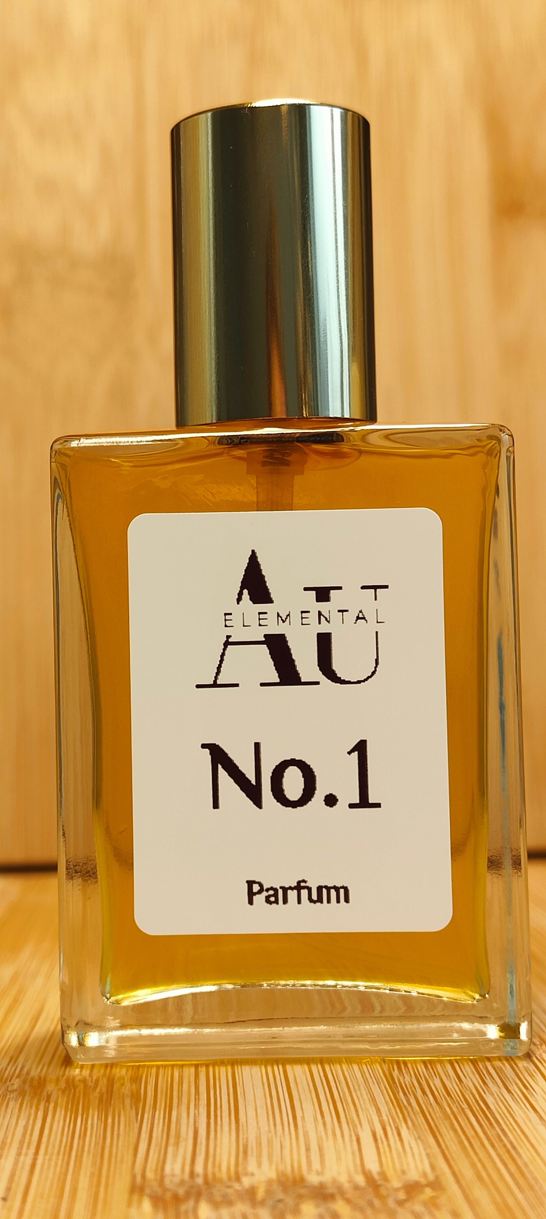 Perfume bottle with gold cap, amber liquid, and white label reading
