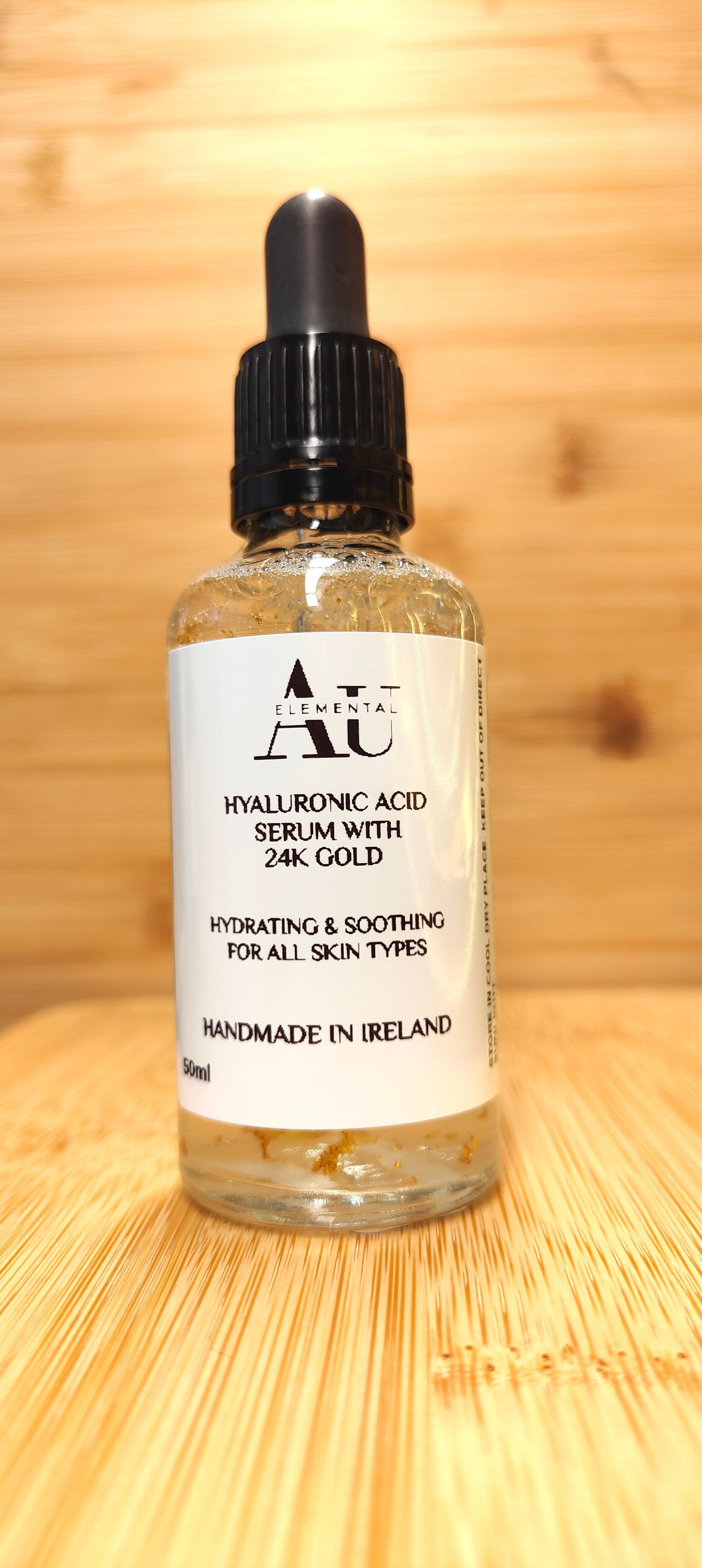 Clear glass bottle with dropper, white label, on a wooden surface.