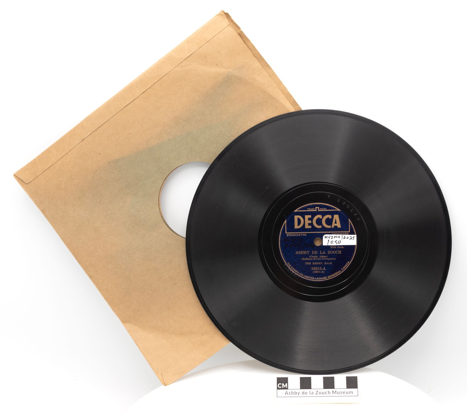 Vinyl record with sleeve. Black disc with a label, sitting next to a brown paper sleeve.
