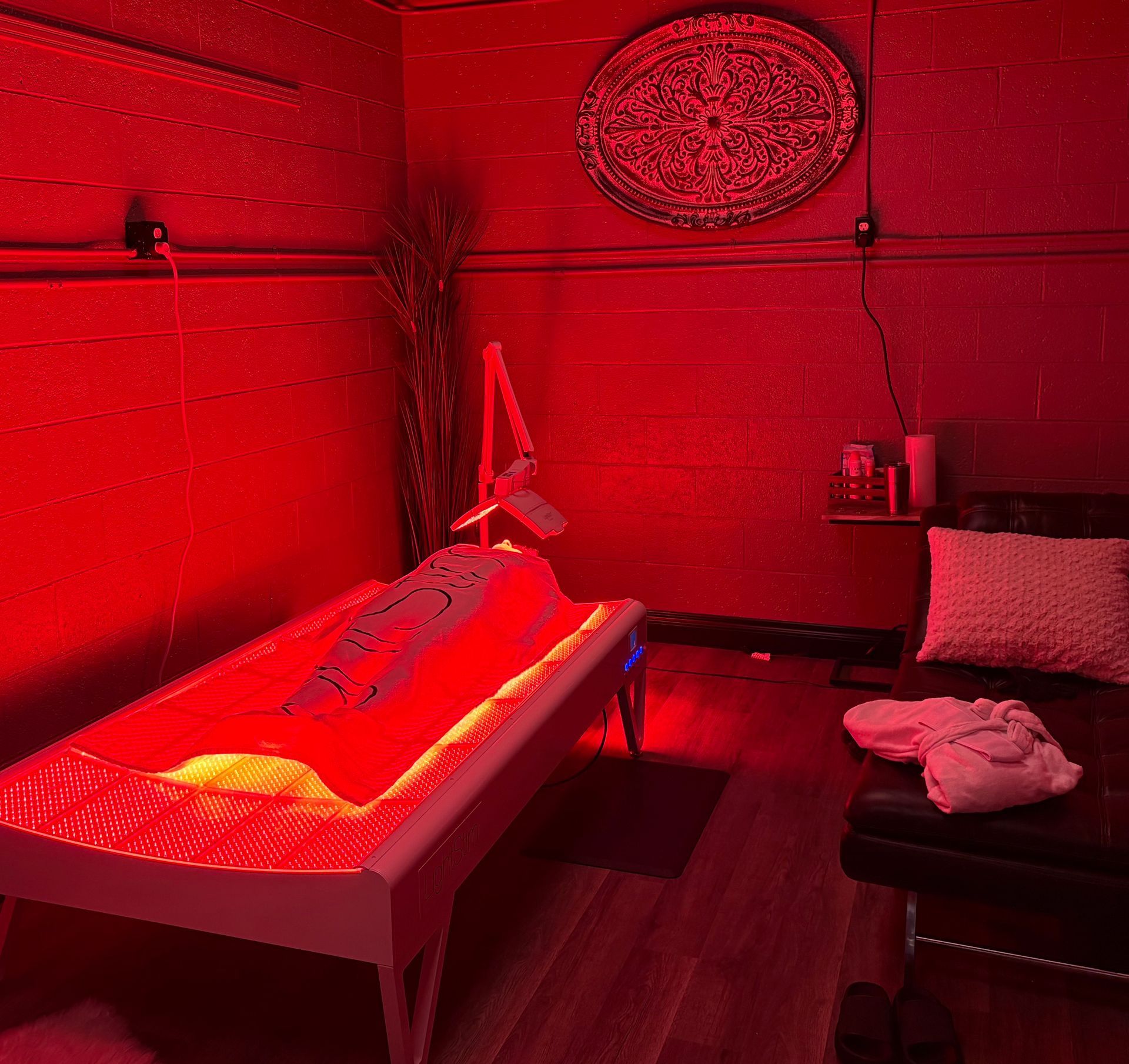 There is a bed with red lights on it in a room.