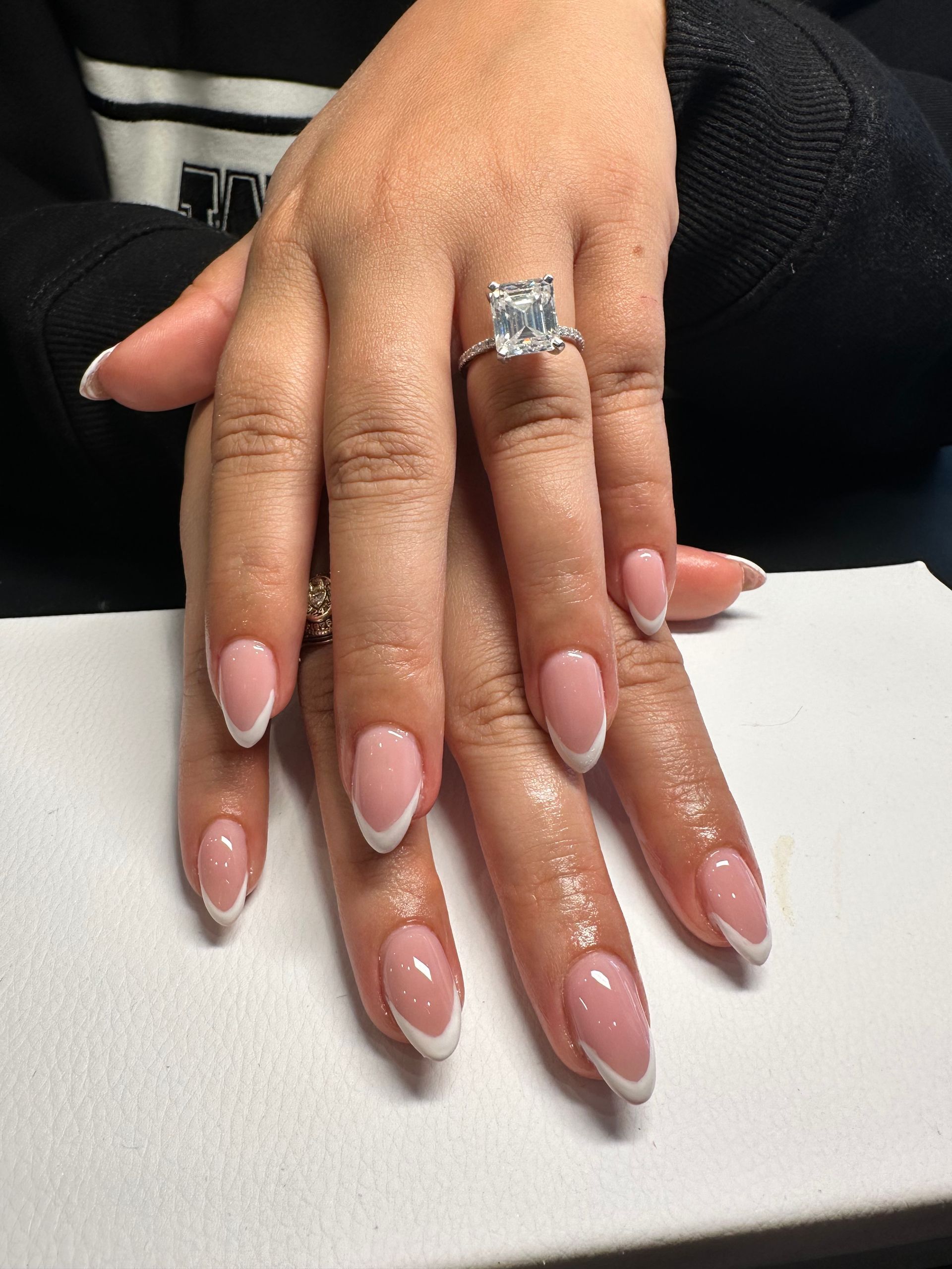 A woman 's hands with french manicure and a ring on her finger