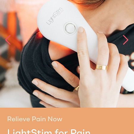 A woman with a ring on her finger is holding a light stimulator