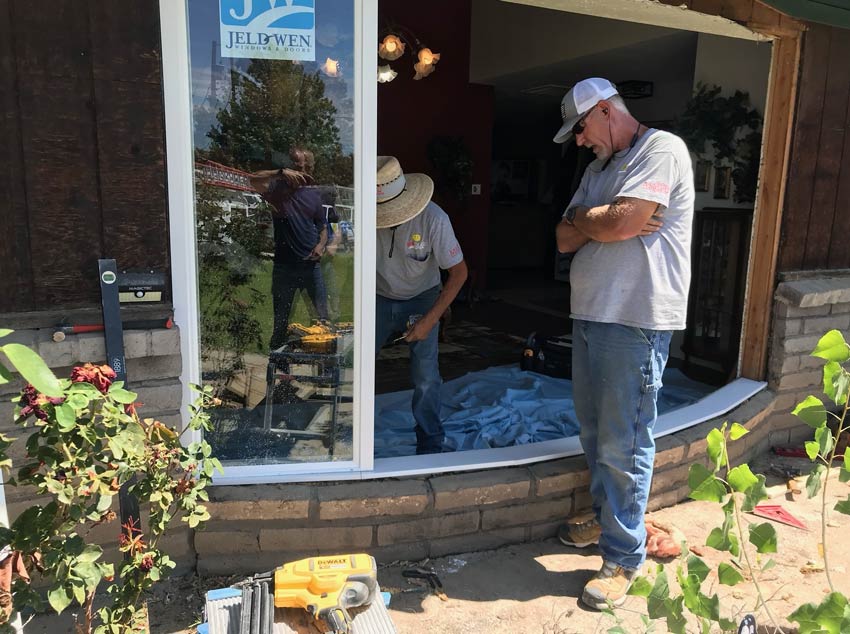 two Sun Glass employees working on a new window being installed by Sun Glass