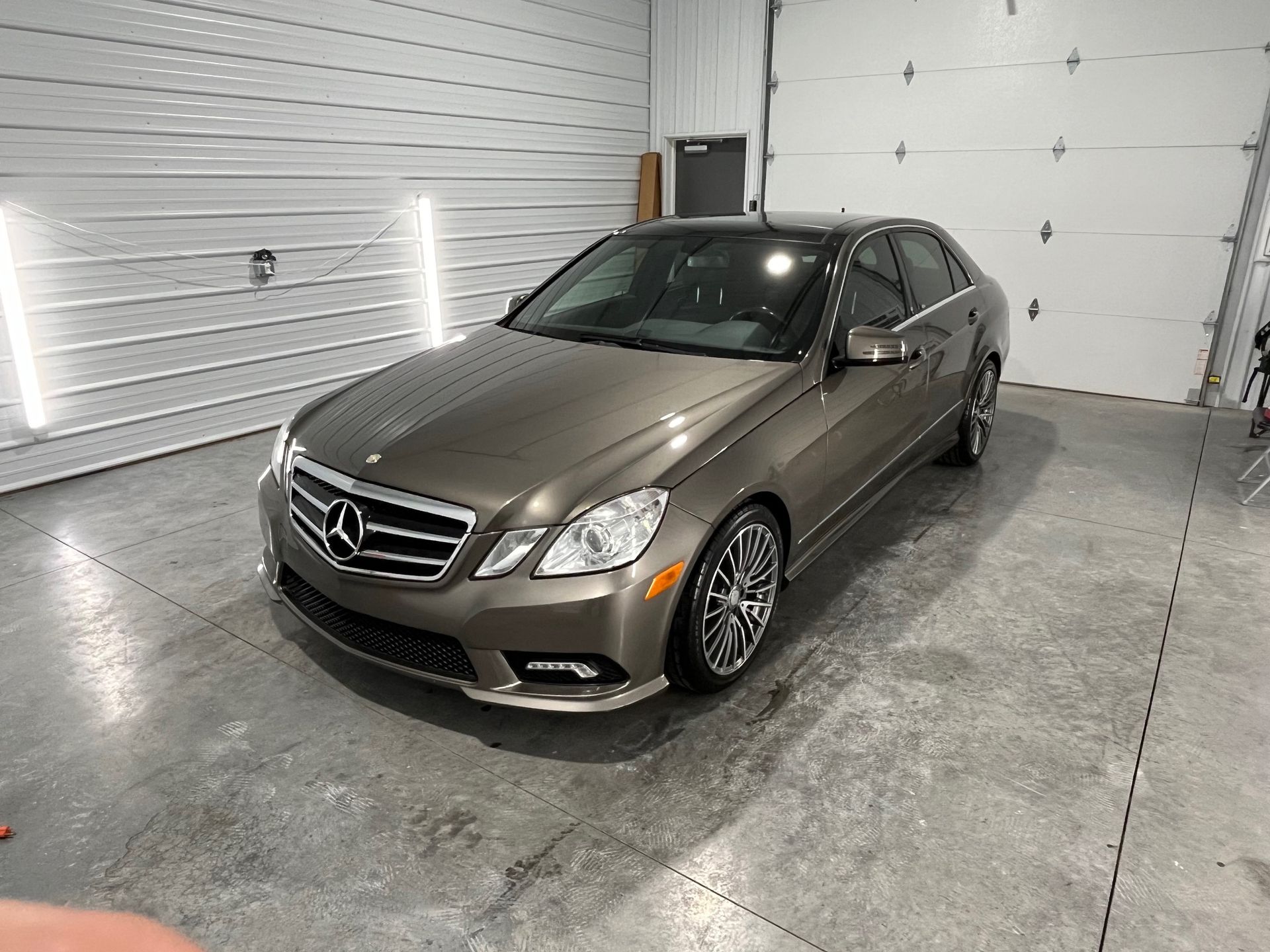 Gray Mercedes sedan parked indoors in a bright garage or showroom