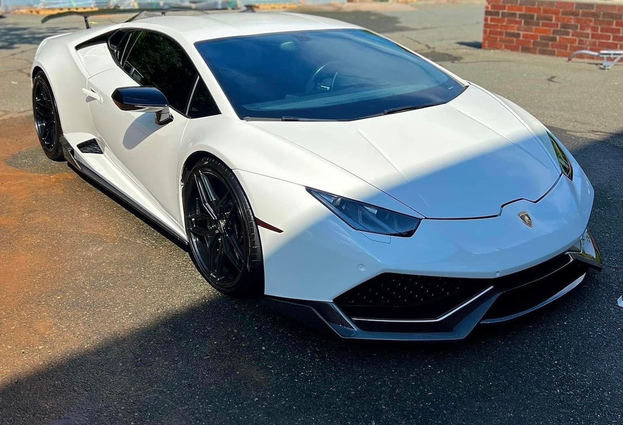 White Lamborghini sports car parked on a street in daylight
