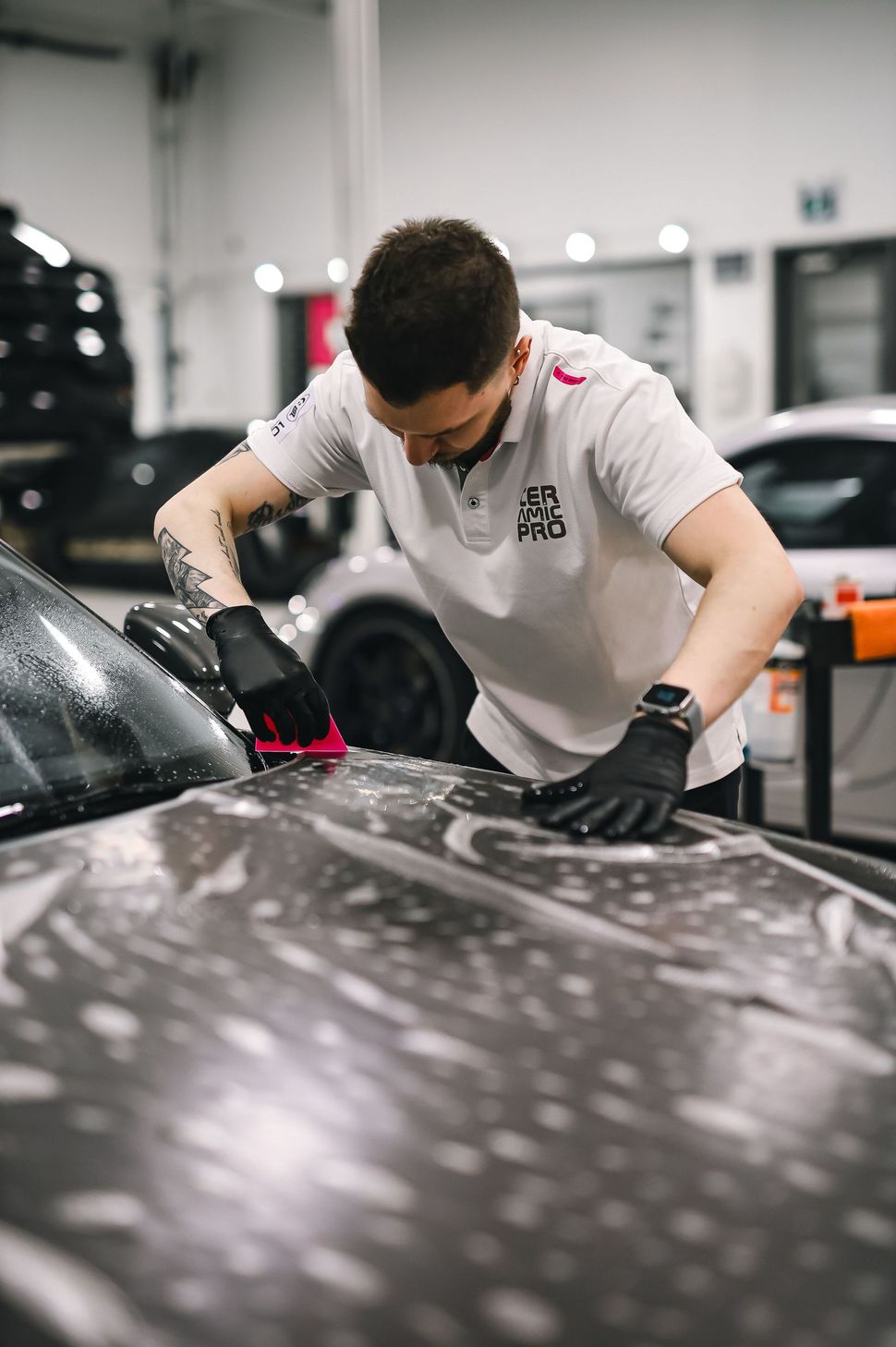 Blue car body panel showing glossy one-step paint correction under bright shop lights