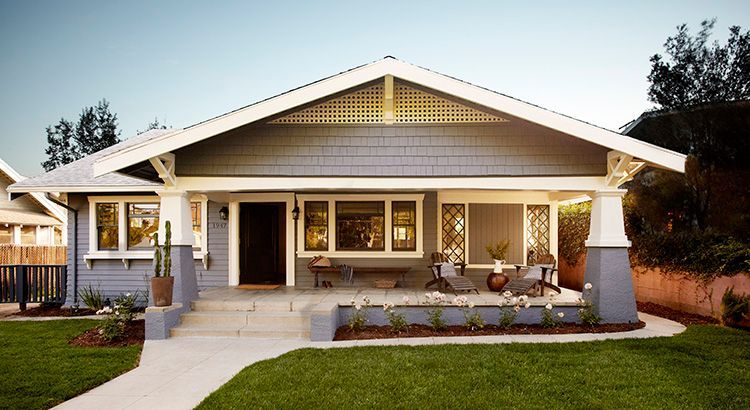 A gray house with a white roof and a porch