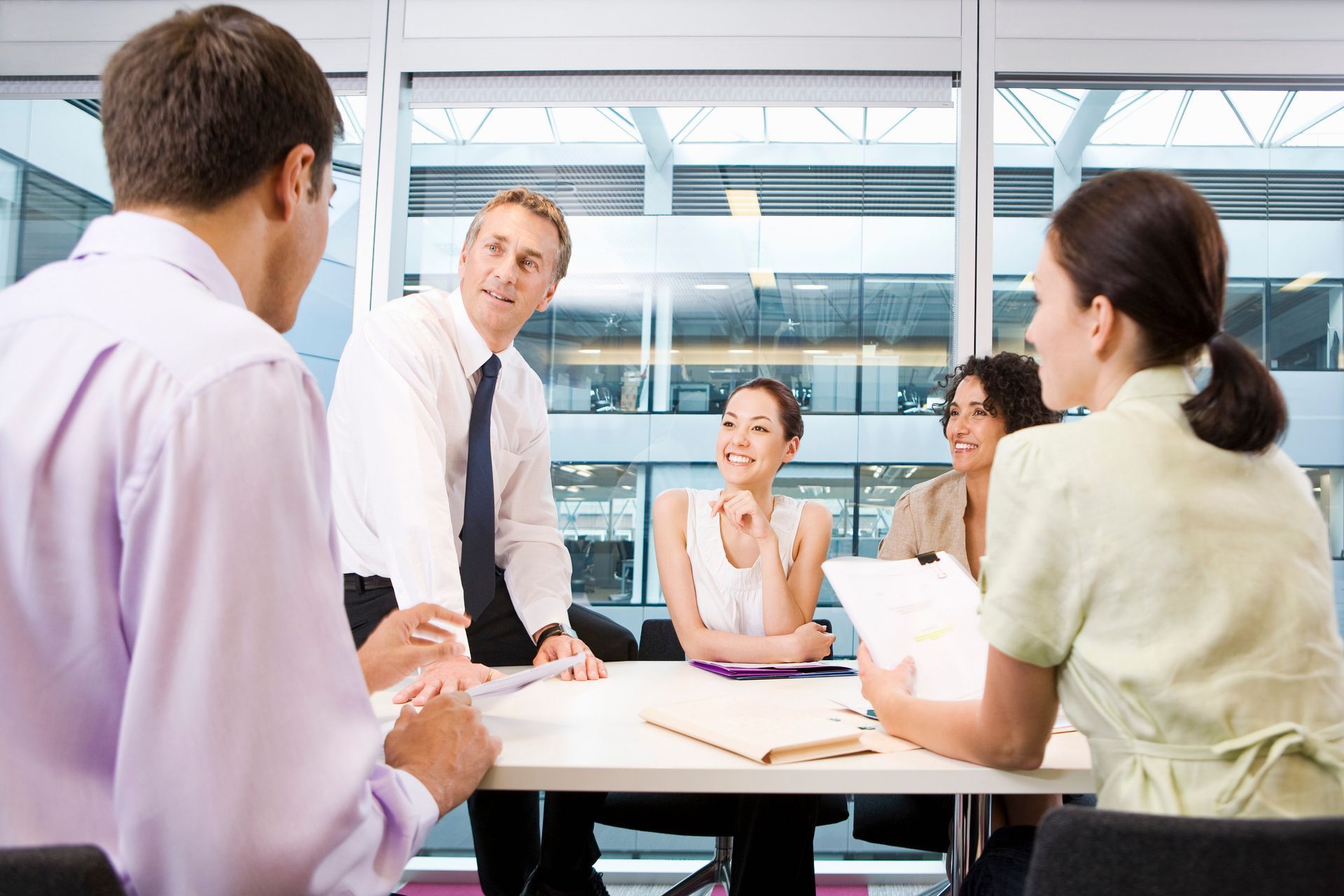 A group of people are sitting around a table having a meeting