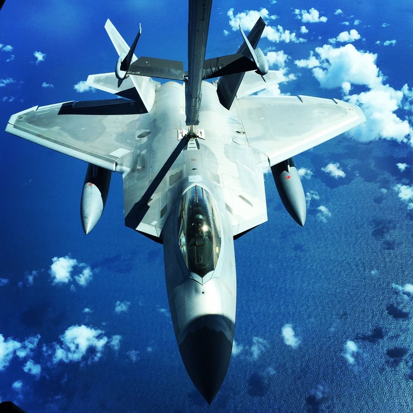 A fighter jet is being refueled in the sky