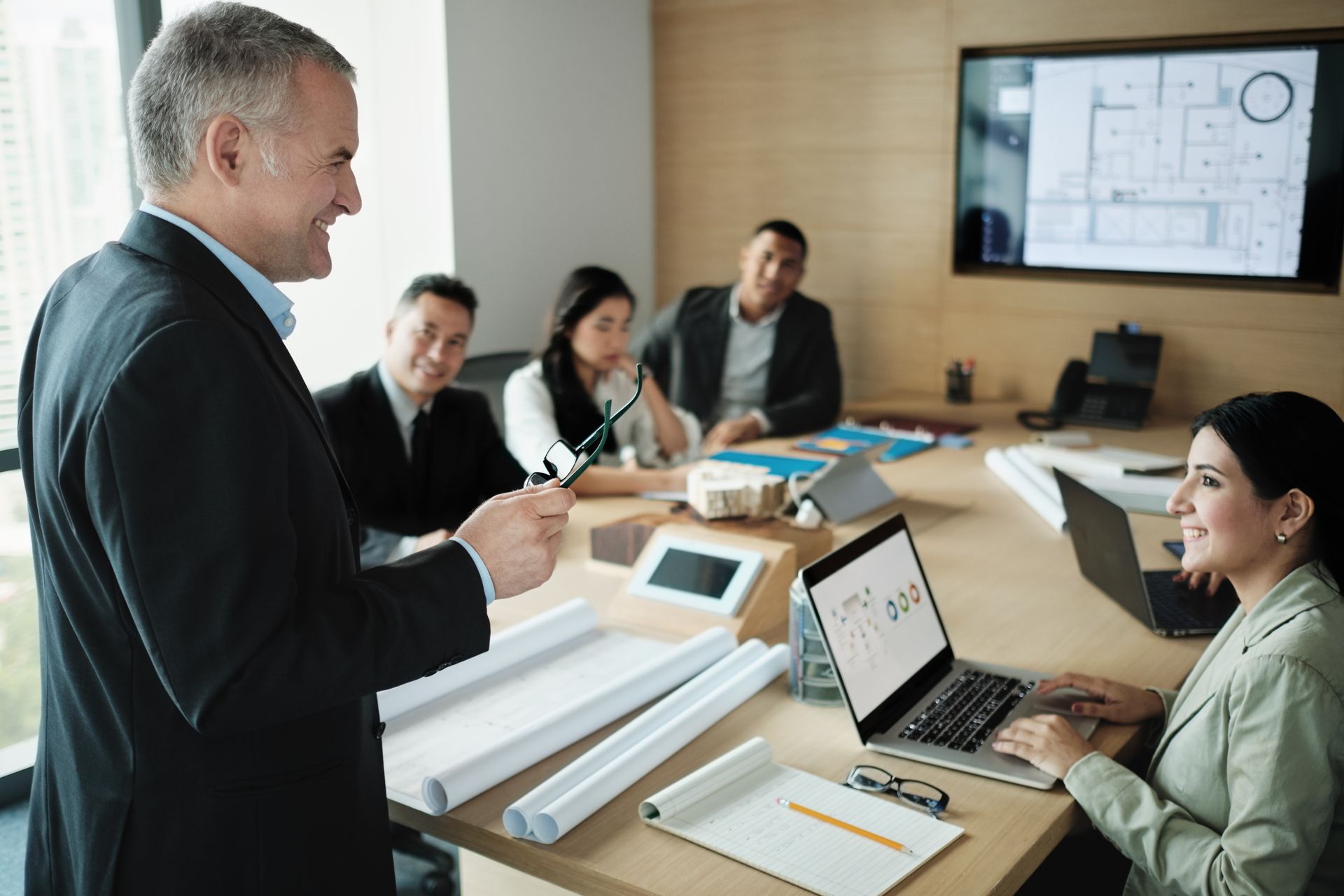 A man is giving a presentation to a group of people in a conference room.