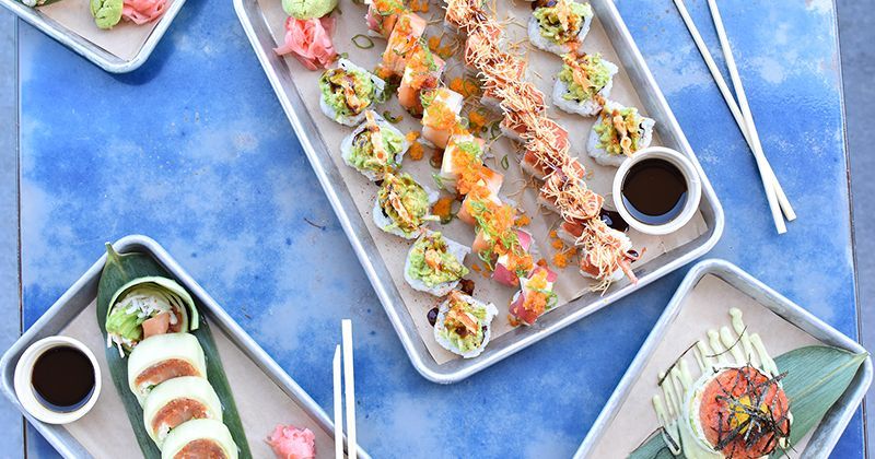A table topped with plates of sushi and chopsticks.