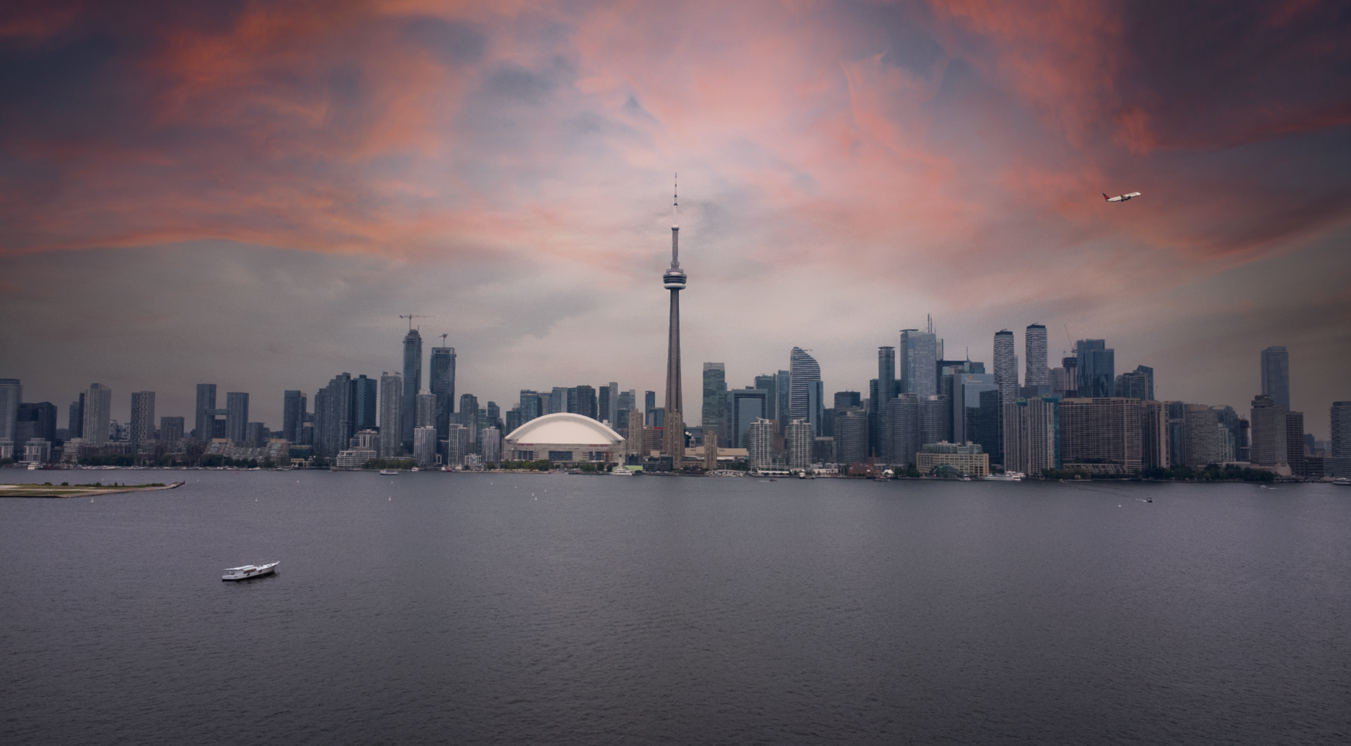 There is a boat in the water in the foreground and a city skyline in the background.