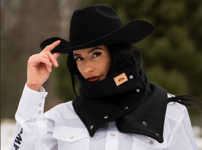 A woman wearing a cowboy hat and a scarf around her neck