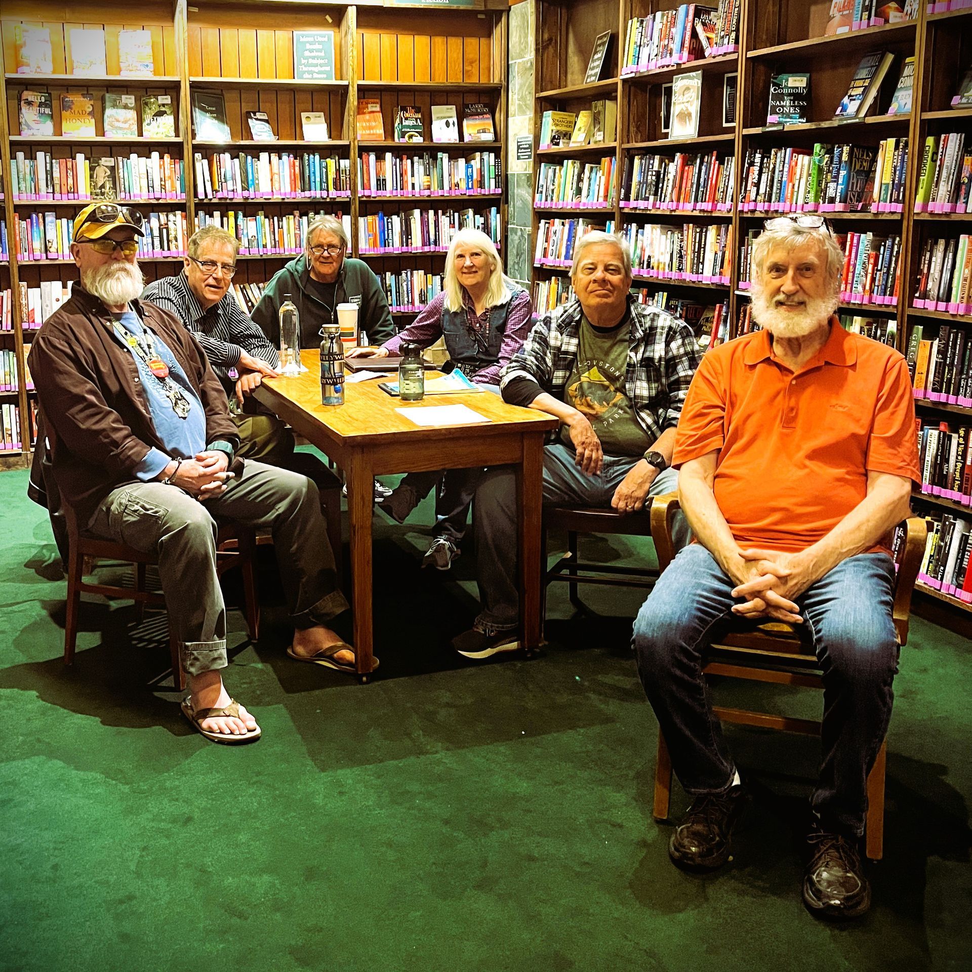 A group of people are sitting around a table in a library