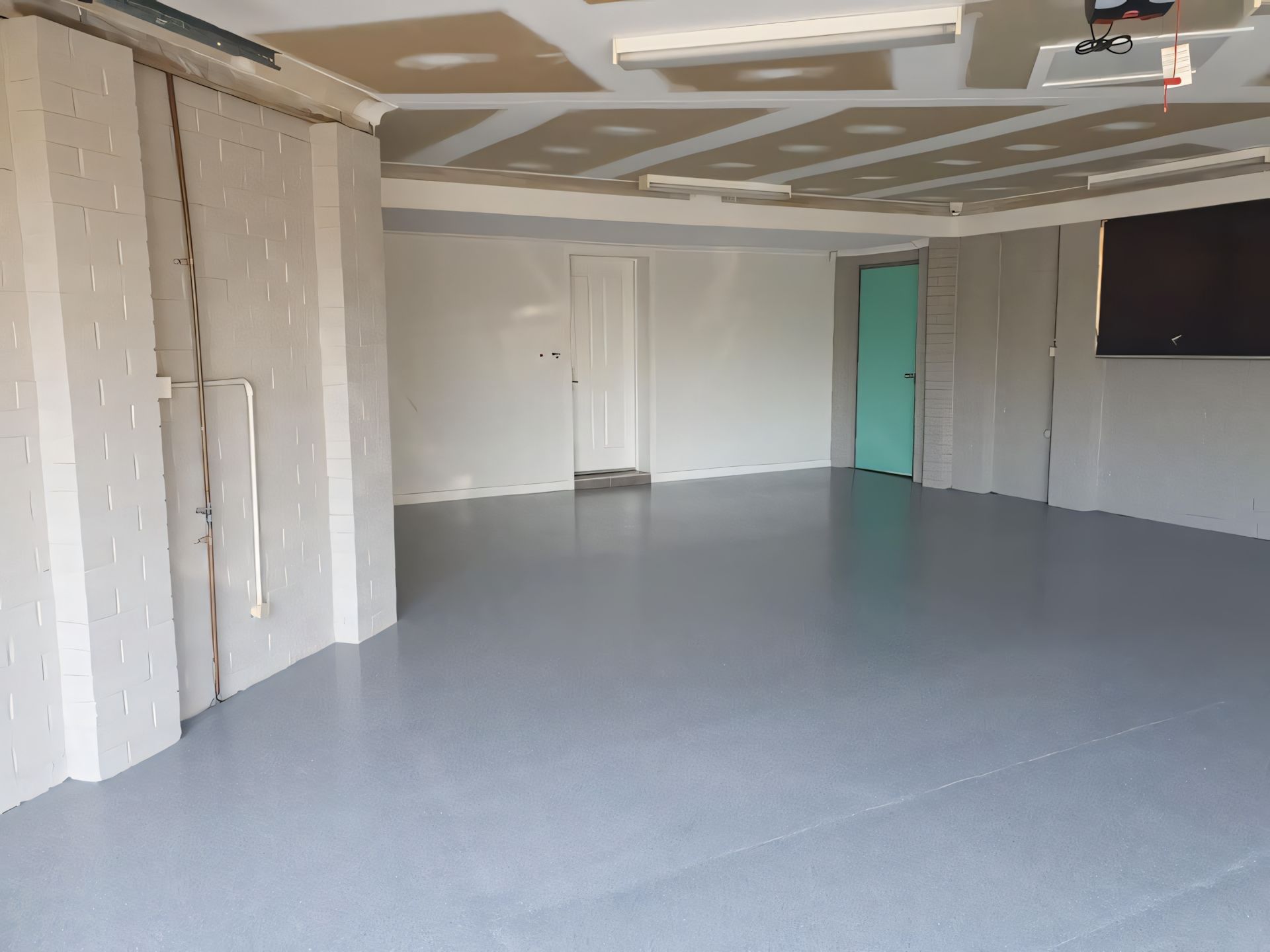 A large empty room with a blue door and white walls  — Partlic Painting & Epoxy Flooring In Taree, NSW