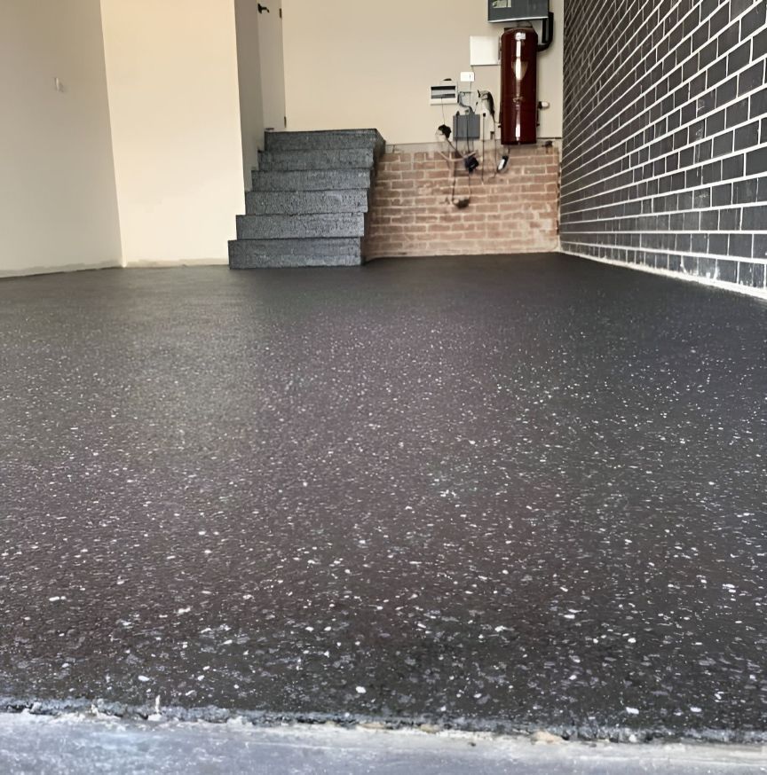 A Garage With A Black Floor And Stairs In The Background — Partlic Painting & Epoxy Flooring In Taree, NSW
