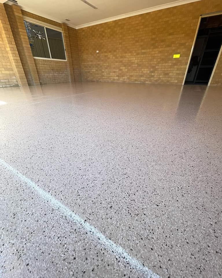 A Garage With A Concrete Floor And A Brick Wall — Partlic Painting & Epoxy Flooring In Taree, NSW