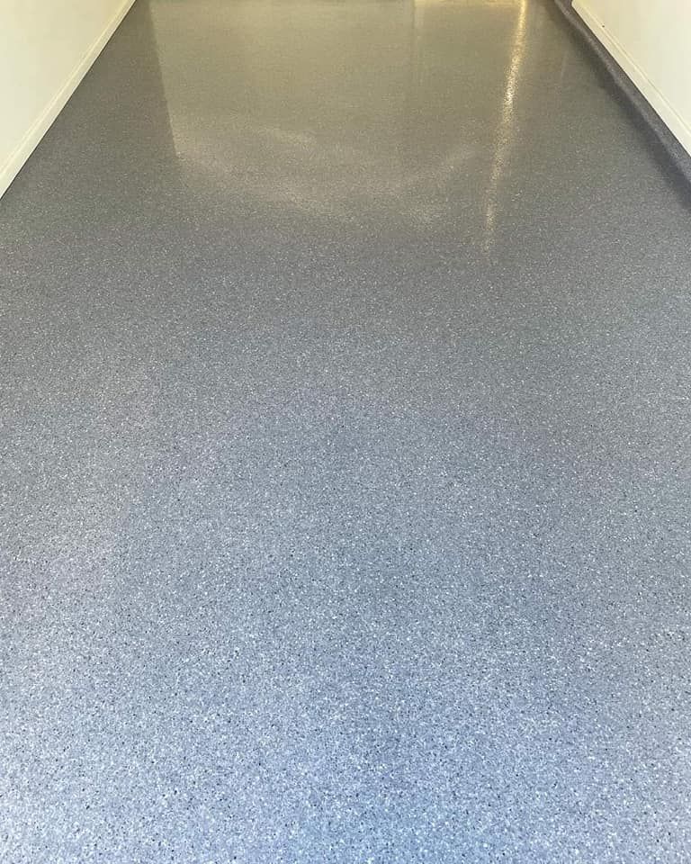 A hallway with a gray floor and a white wall.  — Partlic Painting & Epoxy Flooring In Taree, NSW