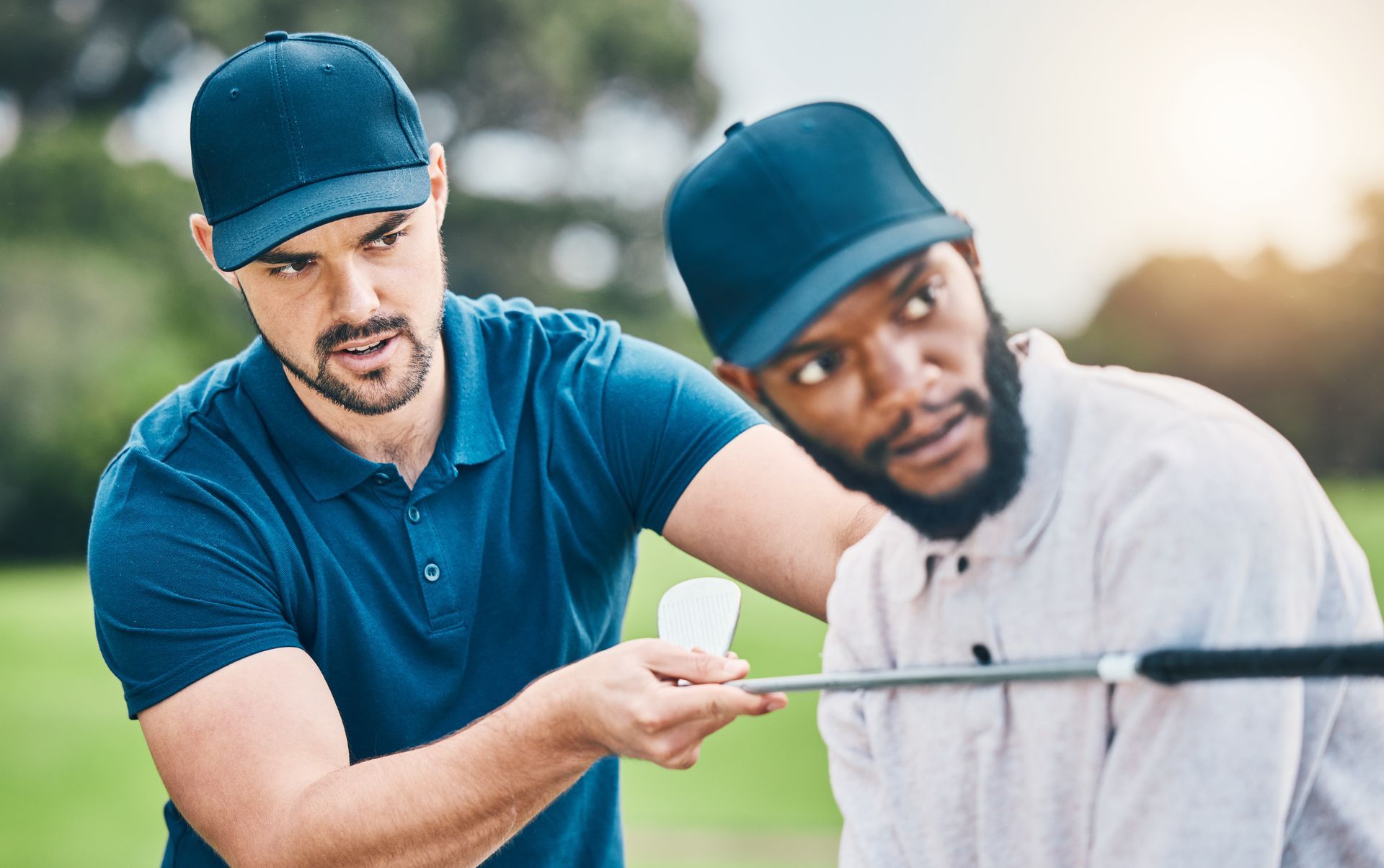 Two workers in blue caps inspect a metal pipe outdoors, one pointing while the other looks on. Two workers in blue caps inspect a metal pipe outdoors, one pointing while the other looks on.