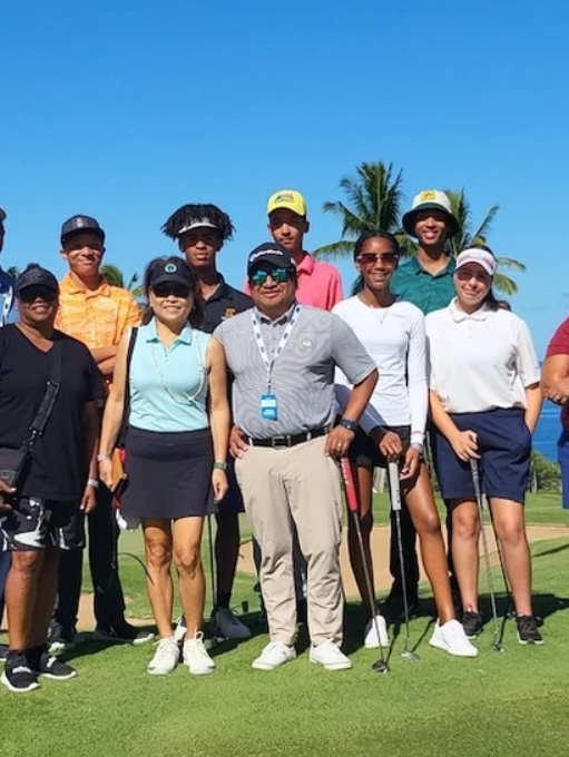 Group of golfers posing on a sunny golf course with clubs and a bright blue sky