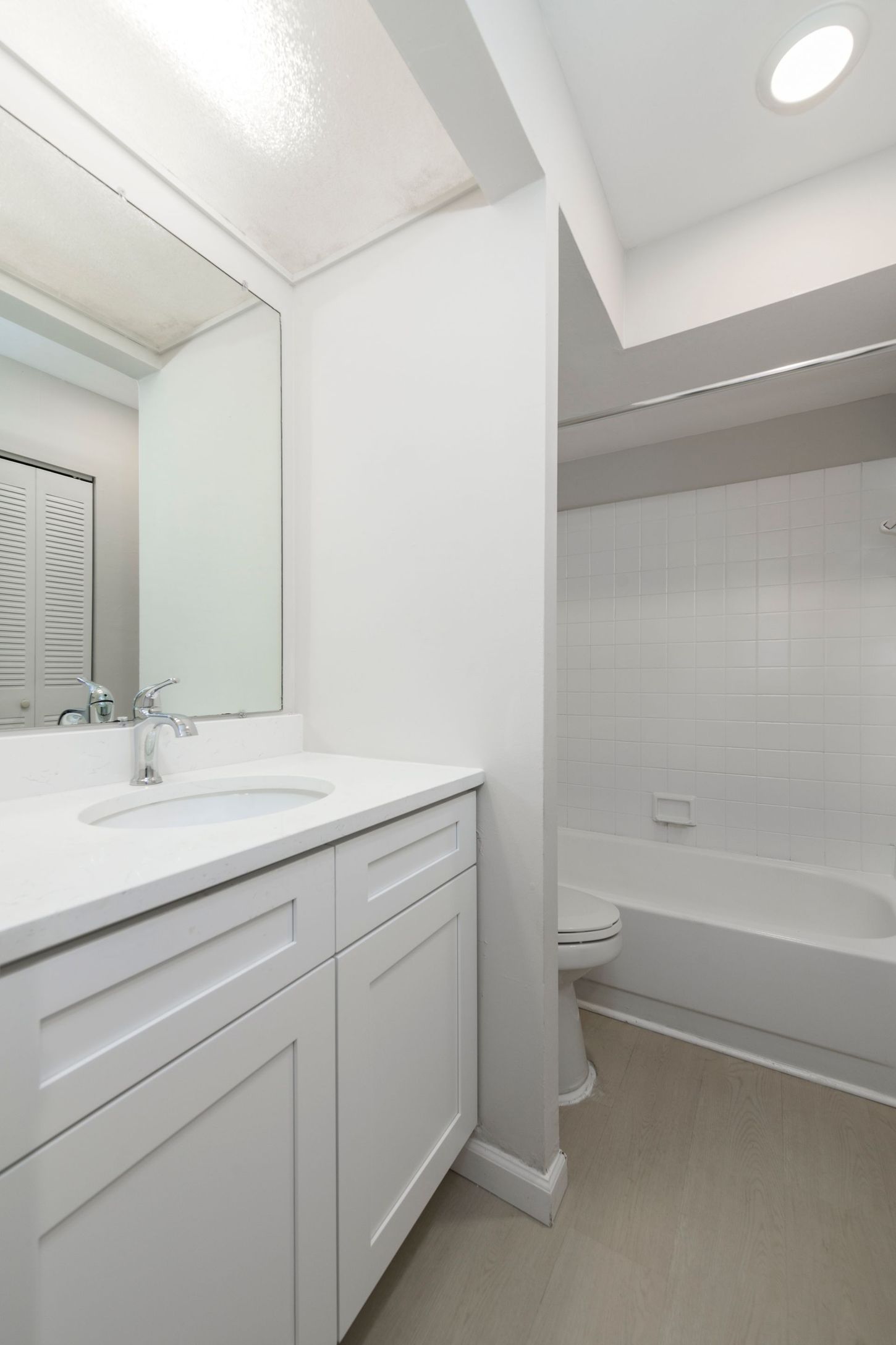 White bathroom with sink, vanity, toilet, and bathtub.