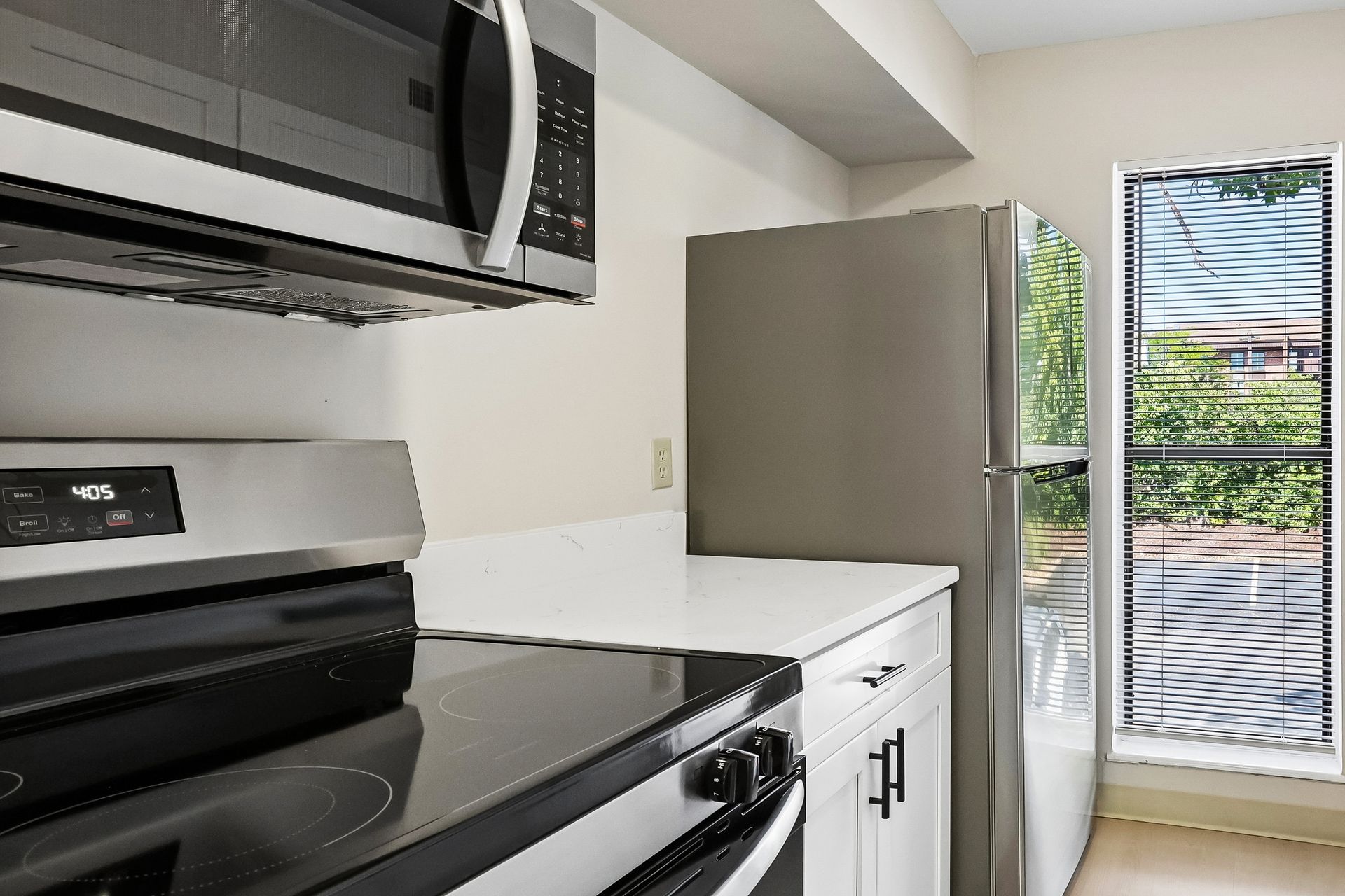 Kitchen with a stove, microwave, and refrigerator at Village Park Apartments
