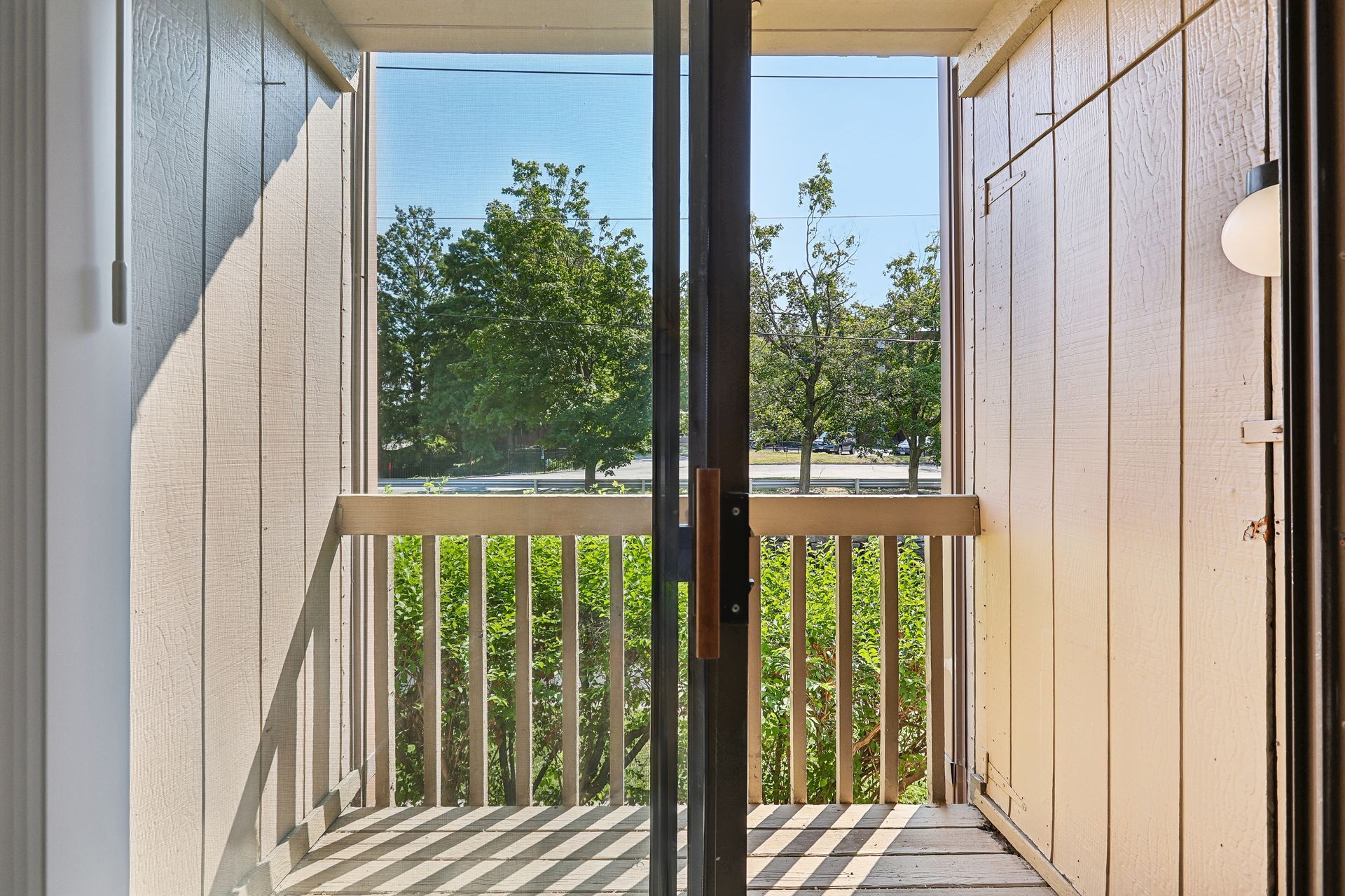 Private balcony overlooking trees at Village Park Apartments