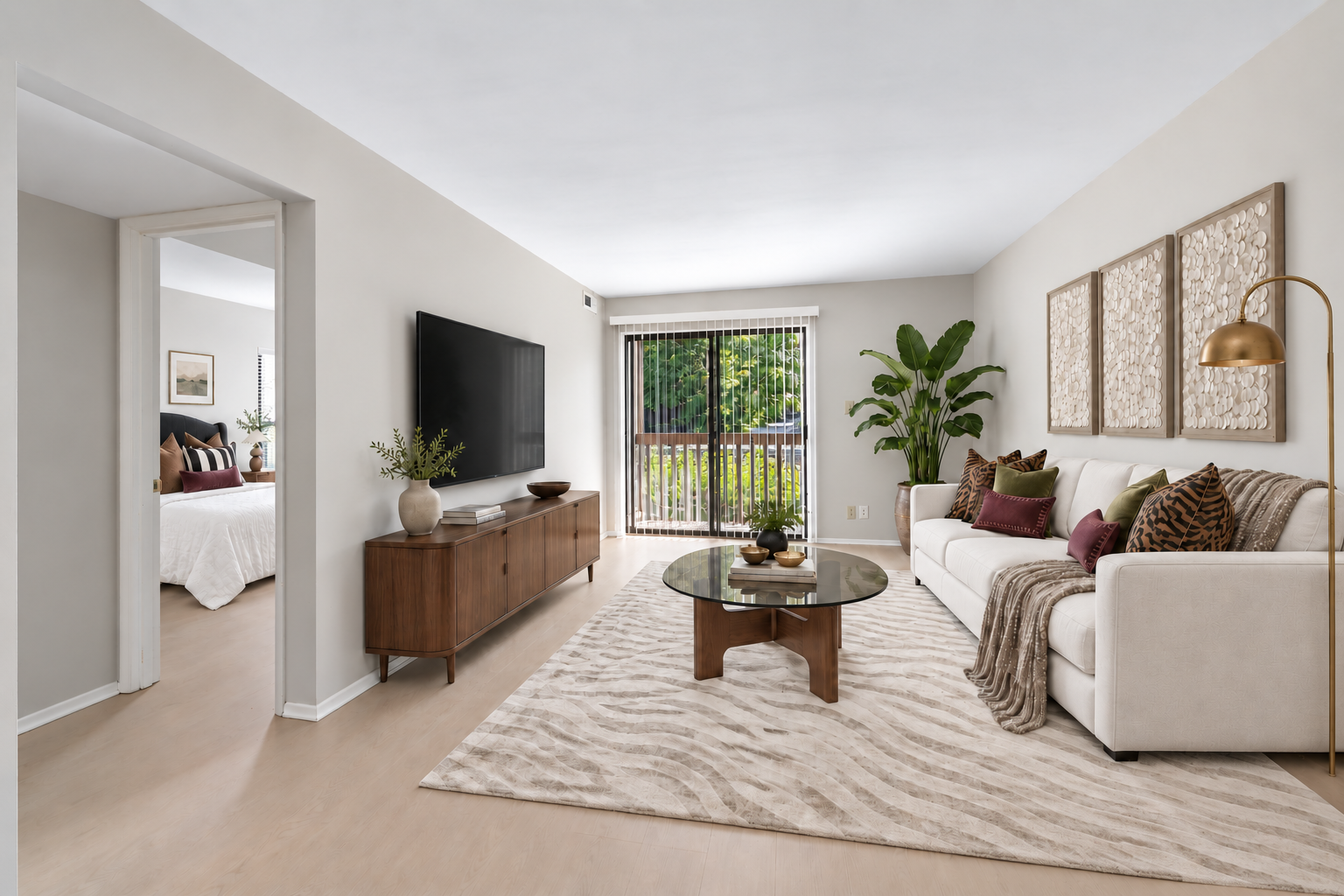 Staged living room with seating and balcony access at Village Park Apartments