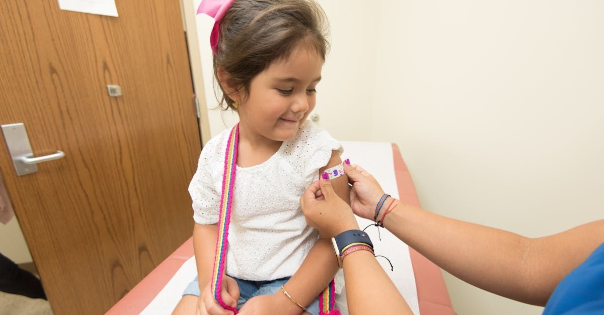 A little girl is being examined by a doctor with a stethoscope.