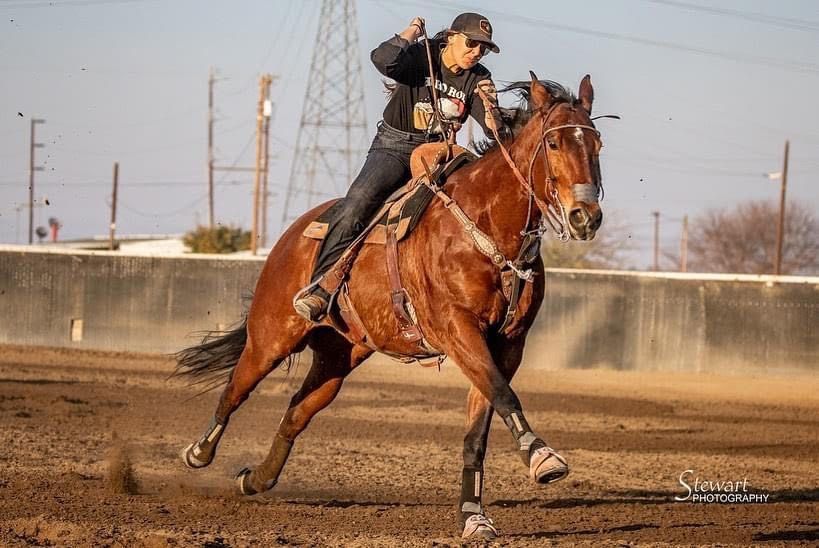 A rider and a paint horse turning around a barrel at a local barrel racing event, exemplifying the sport's dynamic and competitive nature.