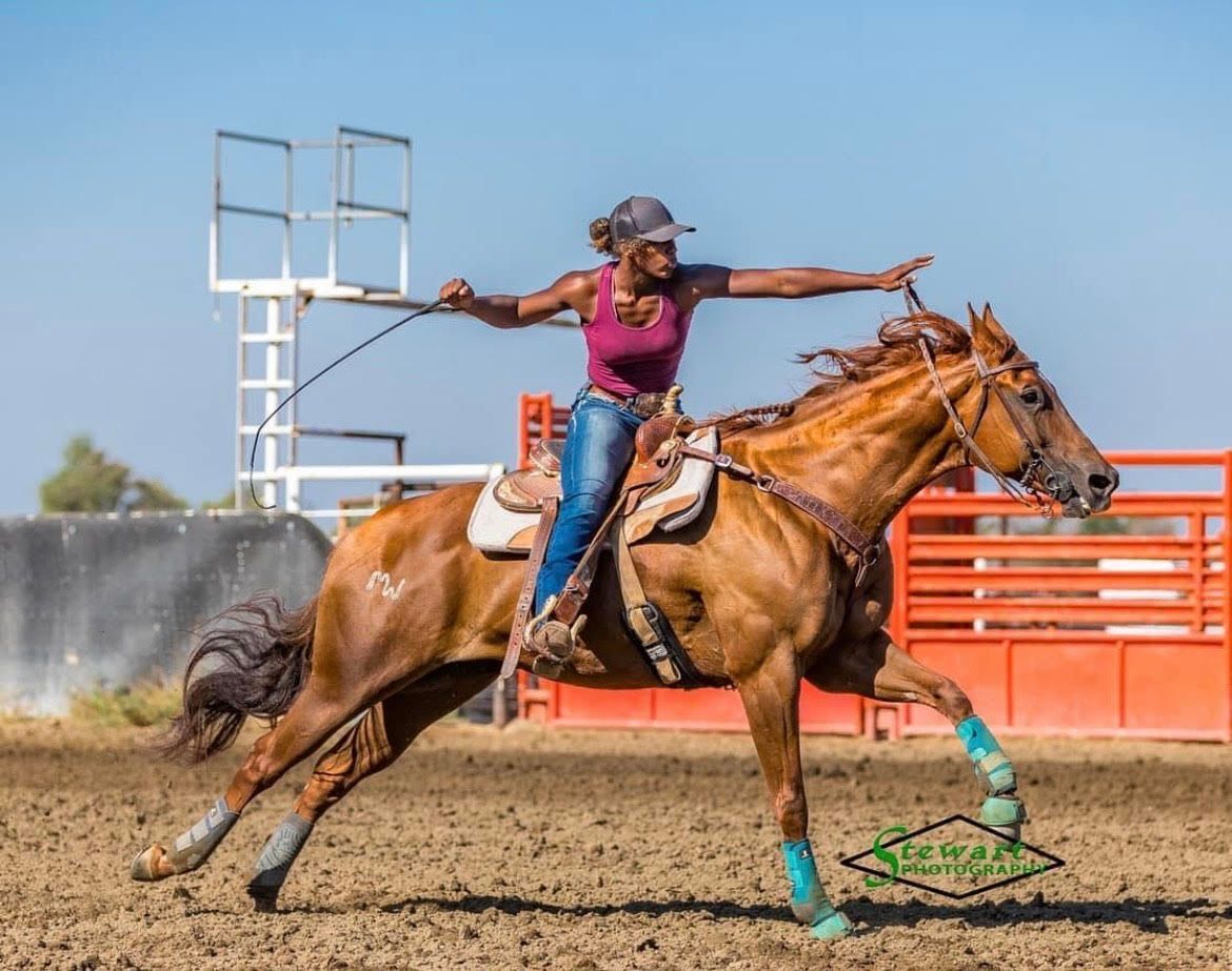 Barrel racer competes in a barrel racing event, turning sharply around a barrel in a sandy arena, exemplifying local barrel racing enthusiasm.