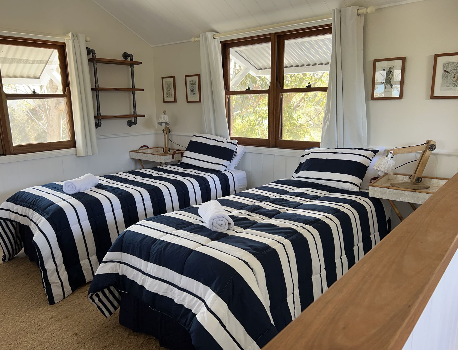 A bedroom with two twin beds and two windows