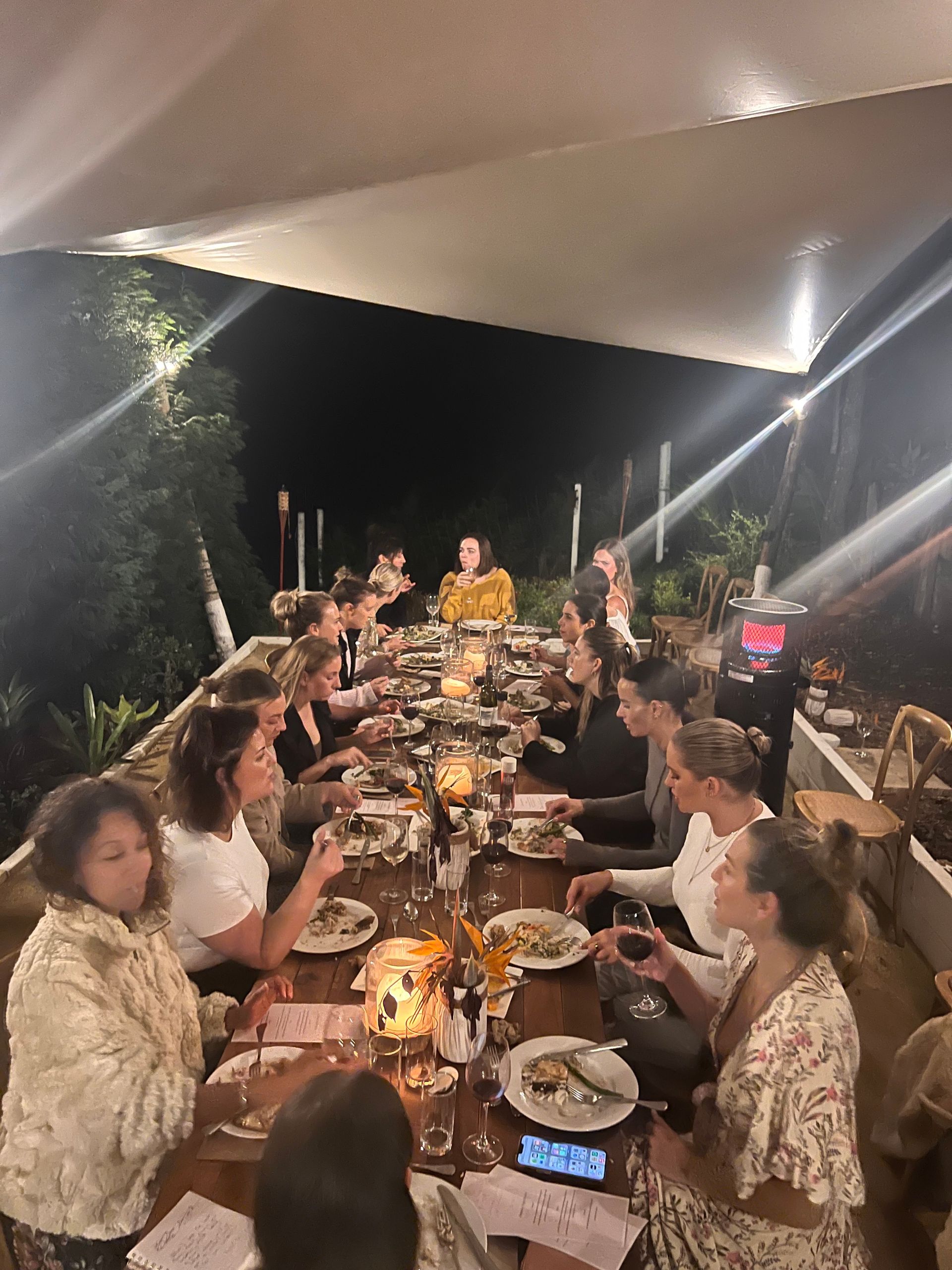 A group of people are sitting at a long table eating food.
