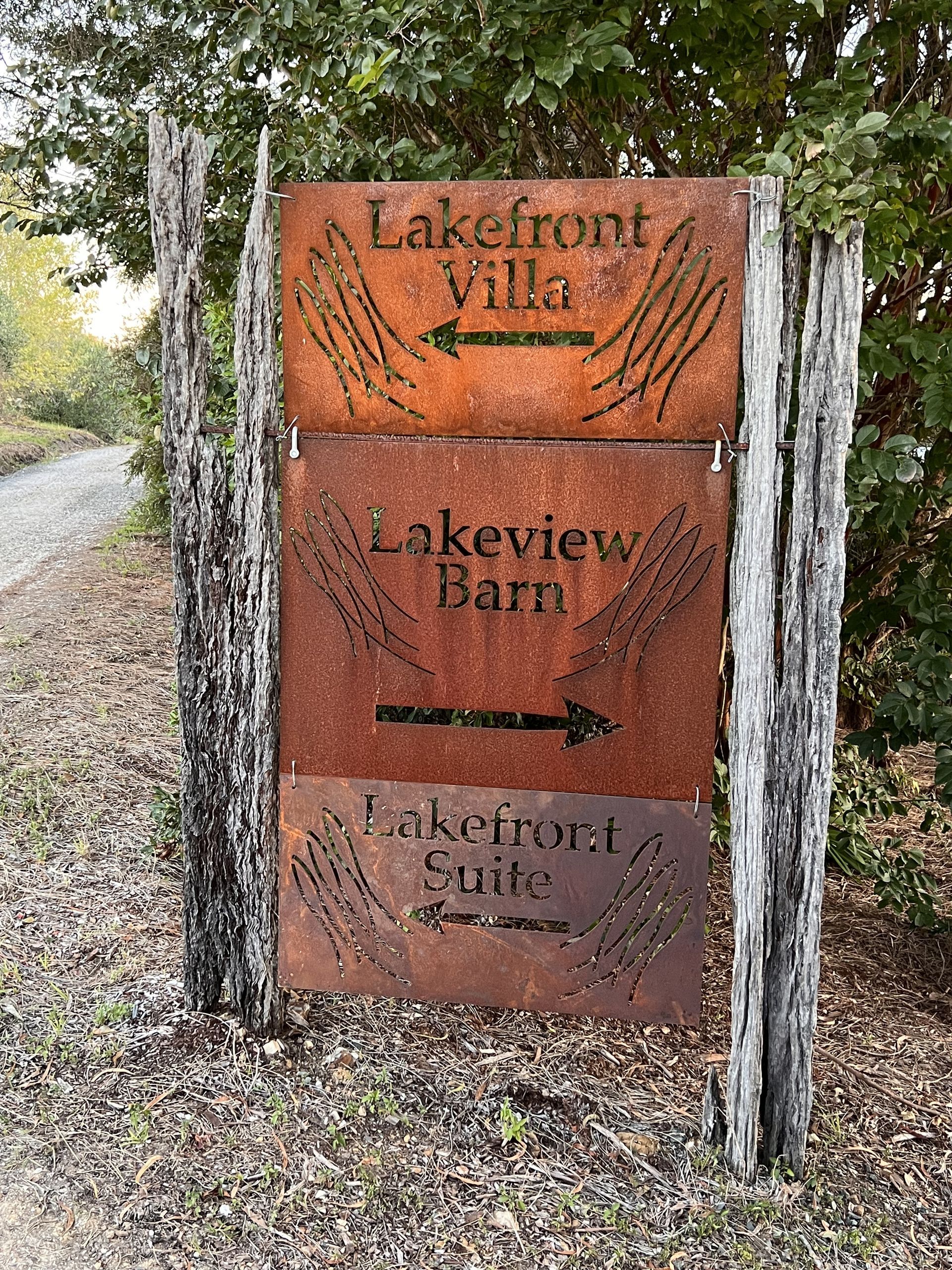 A rusty sign is sitting on the side of a road.