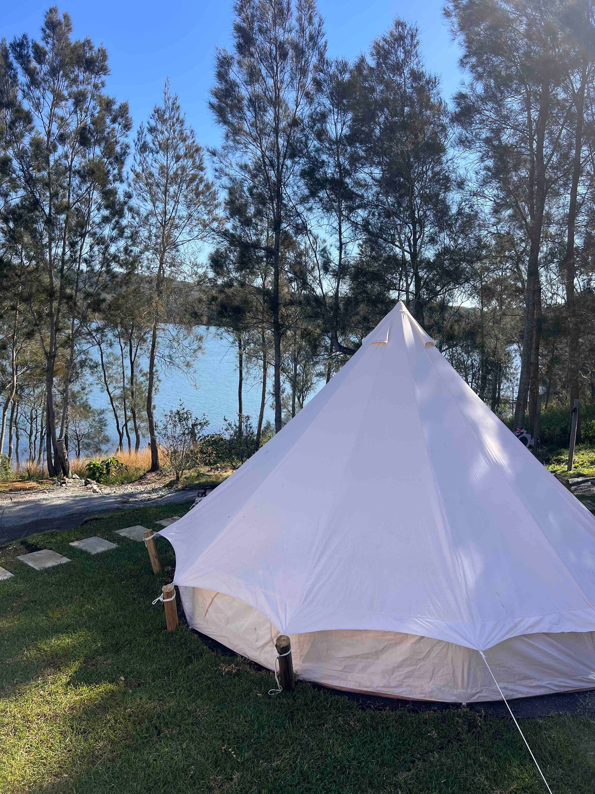 A white tent is sitting on top of a lush green field.
