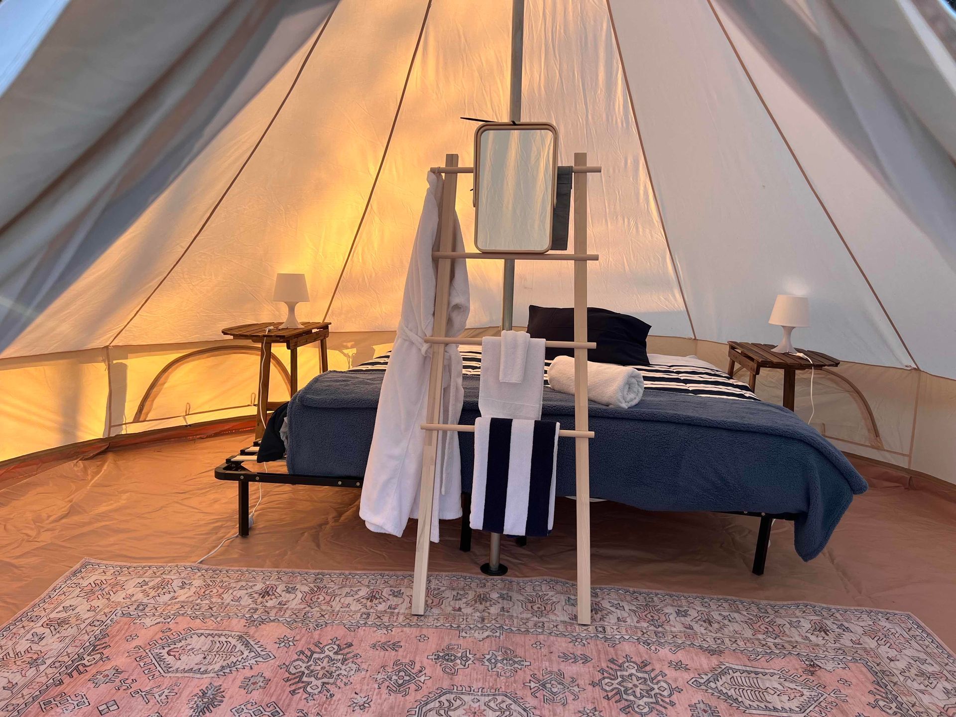 A tent with a bed and a ladder in it